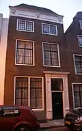 Huis met eenvoudige lijstgevel en schilddak aan de straat