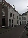 Apart genummerde ingang in gepleisterde zijgevel van het pand Wagenaarstraat 11