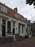 Dwarspand met geschilderde gevel aan de gracht