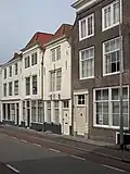 Huis met lijstgevel, aan de hoeken afgeschuind, overkragend op de pui