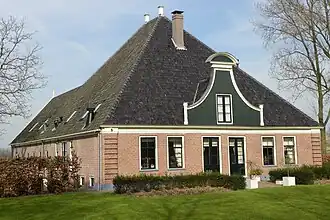 Bakstenen stelphoeve met achterwaarts uitgebouwd bedrijfsgedeelte