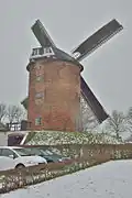 In plaats van de ramen aan deze kant van de molen zat aan de buitenkant de trap met de deuren naar de zolders. Bovenaan de romp ongeveer in het midden zit de dichtgemetselde schoorsteenopening.