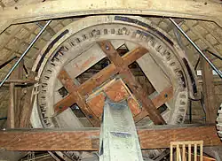 Vang om bovenwiel van de molen De Hoop in Garderen; rechts zit de ophanging en staat de lendestut en links de rijklamp met rust. Ook is links de pal met de drie kammen te zien.