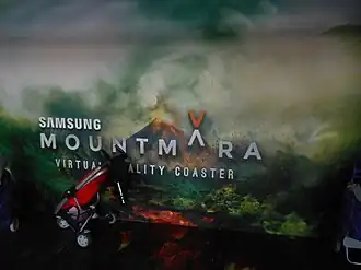 De achtergrondafbeelding in de buggystalling bij de attractie toont de vulkaan uit de rit.