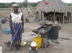 Een vrouw in een capulana destilleert een alcoholische drank, Carneiro, Manica, Mozambique, 2007.