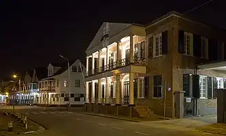 De Mr. Dr.J.C. de Mirandastraat by night: het ministerie van Natuurlijke Hulpbronnen en historische huizen in de richting van de Waterkant