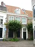 Huis met eenvoudige lijstgevel. Dakkapel met hijsbalk. Gerestaureerd