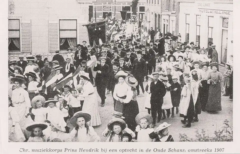 Muziekkorps Prins Hendrik marcheert op de oude schans van Delfzijl in 1907, café op de achtergrond