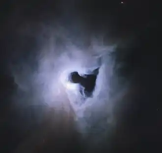 De reflectienevel NGC 1999 (paars) wordt verlicht door de jonge ster V380 Orionis (wit). Voor de nevel bevindt zich een bolwolk (zwart).