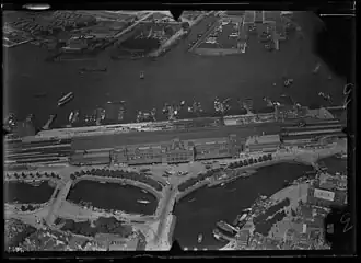 Luchtfoto van het Stationsplein en omgeving met de drie toegangsbruggen: v.l.n.r. brug 13, 306 en 285; tussen 1920 en 1940.