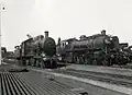 Stoomlocomotief nr. 2119 (serie 2100) van de N.S. (links) en (rechts) de stoomlocomotief nr. 6911 van de N.M.B.S. (Belgische Spoorwegen) te Roosendaal. (1939)