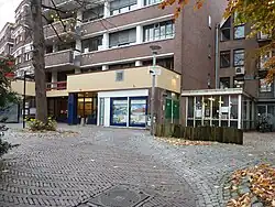 Binnenplein vanaf Popkenstraat. Passage rechts van blauwe paal.