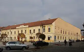 Links: de voorgevel aan het plein: "Námestie baníkov". Rechts de zijgevel aan de: "Cucmianska dlha".