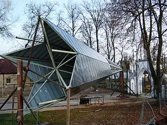 Een nieuwe spits ligt klaar voor de reconstructie van de torens, na brand in de Sint-Mattheuskerk in Naujamiestis (Letland)