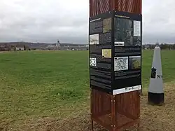 Infozuil naast grenspaal met Navagne op de achtergrond