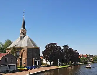 De Woudwetering in Woubrugge met de Nederlands-hervormde kerk