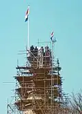 Officiële plaatsing van de windhaan op de nieuwe spits in 1983.