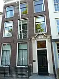 Pand met lijstgevel met consoles onder kroonlijst en gebeeldhouwde deuromlijsting, aanvang xviii, hek
