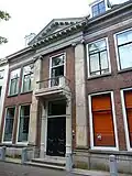 Statig herenhuis, pilasters grote orde, ter weerszijden van middenpartij door tympaan gedekt