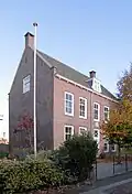 Statig huis met rechte kroonlijst, in topgevels eindigend