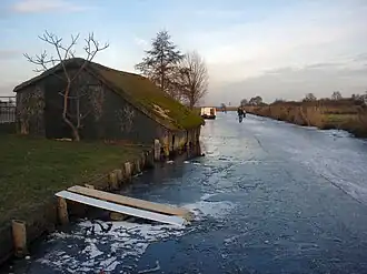 De Noordlaardervaart in de winter met links een boothuis