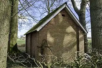 Achterzijde baarhuisje met links de nortonpomp