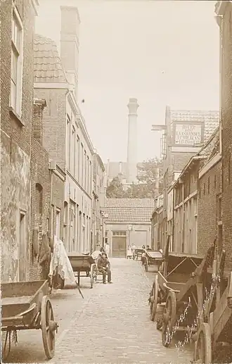 Dwarsbolwerkstraat gezien van de Kraaierstraat naar de Bolwerkstraat. Links en rechts geparkeerde handkarren