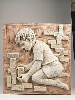 plaat met decor van jongen spelend met stenen