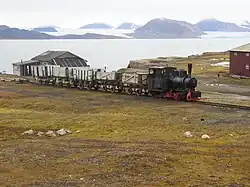 Oude stoomtrein in Ny-Ålesund, met op de achtergrond de Kongsfjorden en zijn imposante gletsjers