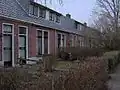 Blok van acht arbeiderswoningen in ambachtelijk-traditionele stijl