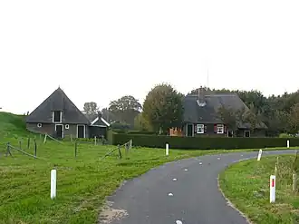 Boerderij onder met riet gedekt wolfdak. Behoort tot het landgoed "De Haere". Op het erf een bakhuis en stenen schuur met rieten schilddak