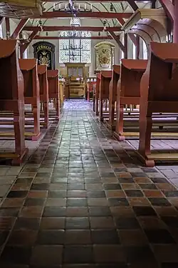 Het in de jaren 1950 warmrood geverfde interieur van de kerk gezien vanuit het westen