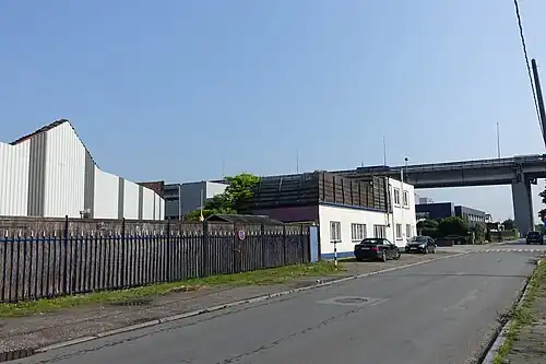 Zicht op het viaduct van Vilvoorde in de achtergrond. Centraal een woning in het industriegebied. Uplace zou rechts van de straat op de voorgrond komen.