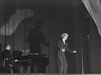 Jan Broekhuis op piano, bij een optreden van Charles Trenet in het City Theater in Amsterdam, dec. 1945