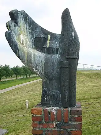 Het Monument voor Oterdum op de dijk. Op de achtergrond de industrie (2007).