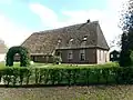 Boerderij met achterbaander en steil dakschild boven de korte zijde van het woondeel van de J Nijenbanning clan