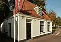 Laag huis met rechte kroonlijst nabij de Amstelkerk (Hervormde kerk)