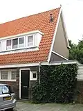 Blok met 8 keukenwoningen, zo genoemd vanwege destijds nieuwe plaatsing van keuken aan de voorzijde, aan de zijkant een houten topgevel, bouwstijl Amsterdamse School, samen met de poortgebouw langs de Purmerweg centraal deel van Tuindorp Nieuwendam