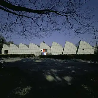 Westgevel met schuine betonplaten die de dakstructuur volgen