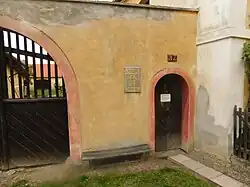 Oude poort met gedenkplaat van de familie Šubrtů