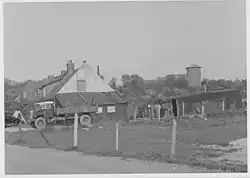 Woning met schuren en vrachtwagen. Op de achtergrond de watertoren in het Sterrebos.