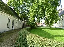 Links de 16e-eeuwse pastorie. Rechts de kerk.