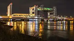 De geopende Botlekbrug. Op de voorgrond is de oude spoorbrug te zien.