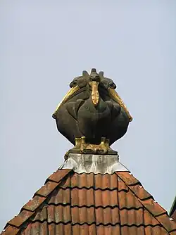 Daksculptuur van vier pelikanen door J. Mendes da Costa