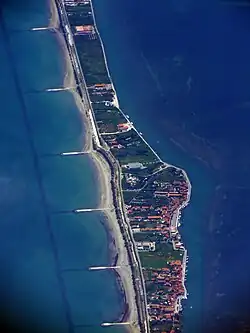 Een deel van het eiland Pellestrina vanuit de lucht; aan de zeezijde (links) zijn de strandhoofden duidelijk te zien