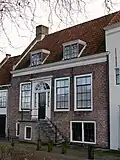 Huis met lijstgevel, onderbouw gecementeerd