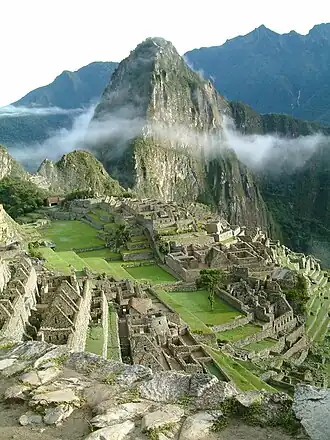 De Huayna Picchu steekt uit boven de ruïnes van Machu Picchu