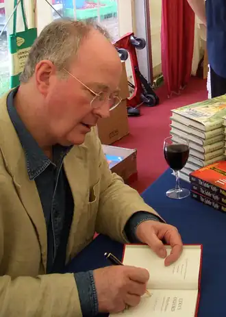 Philip Pullman signeert in boek tijdens het Oxford Literary Festival in april 2005.