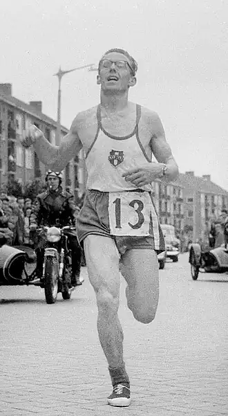 Piet Bleeker passeert de finish bij het NK marathon 1958 in Zaandam
