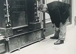Plaatsing vloedplank in de Voorstraat in Dordrecht, voorafgaand aan een verwachte stormvloed in 1955